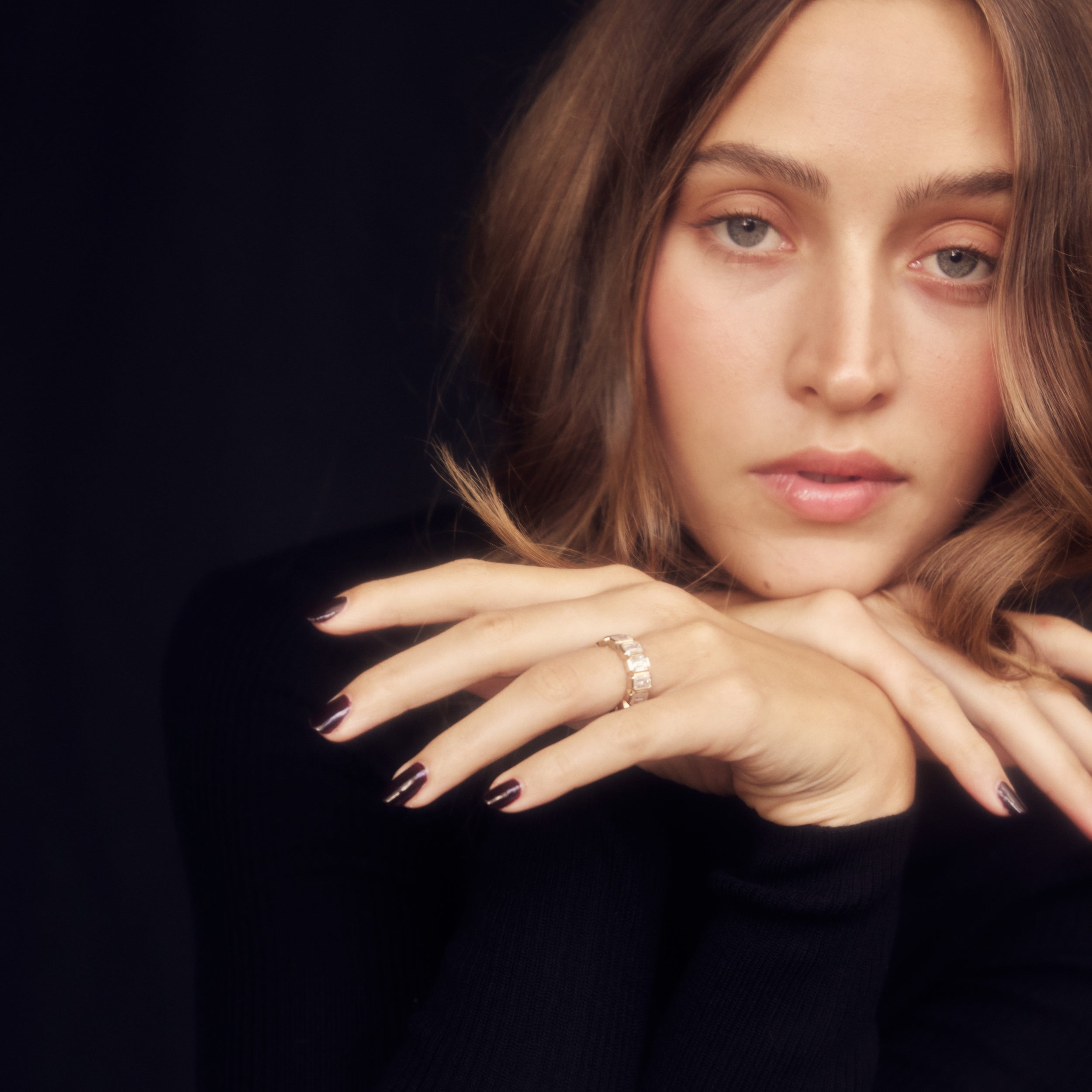 Moissanite emerald cut bezel eternity band on model wearing all black